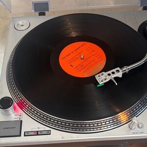 Audio Technica Silver Turntable with Black Vinyl and Orange Label